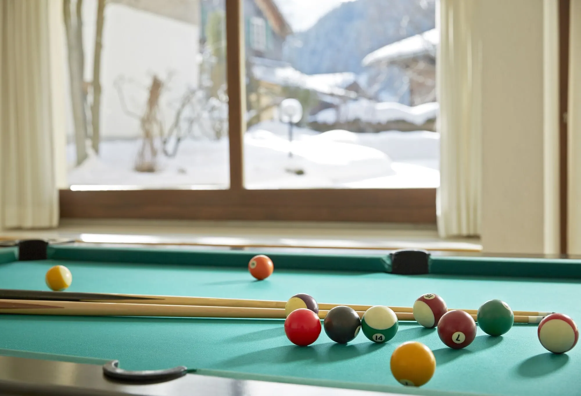 A billiard table by a snowy window