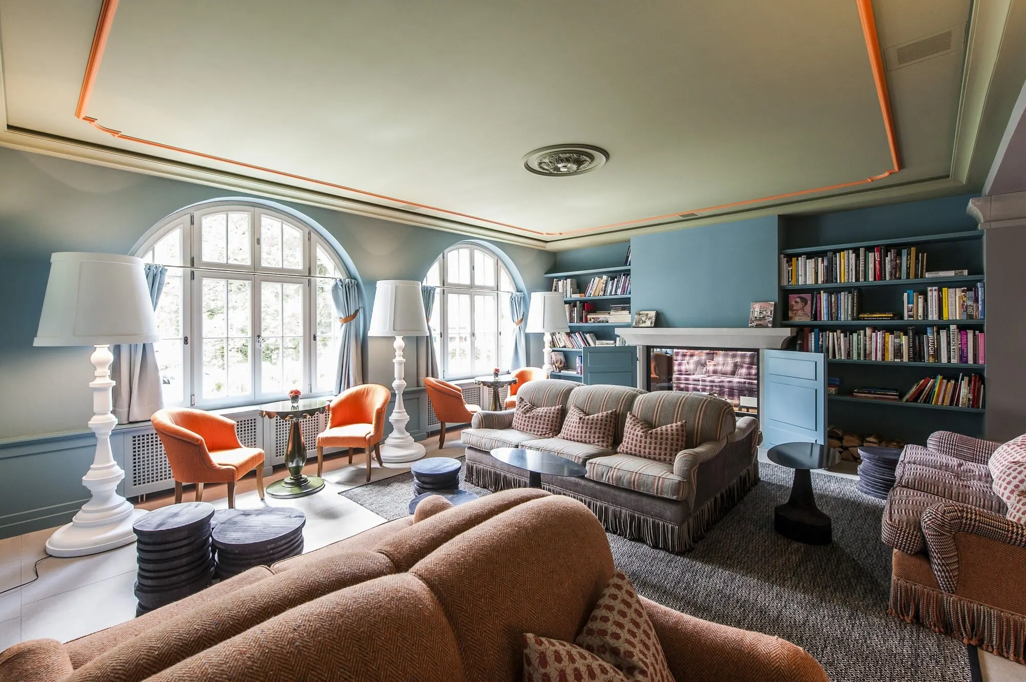 A lounge with bookshelves and arched windows