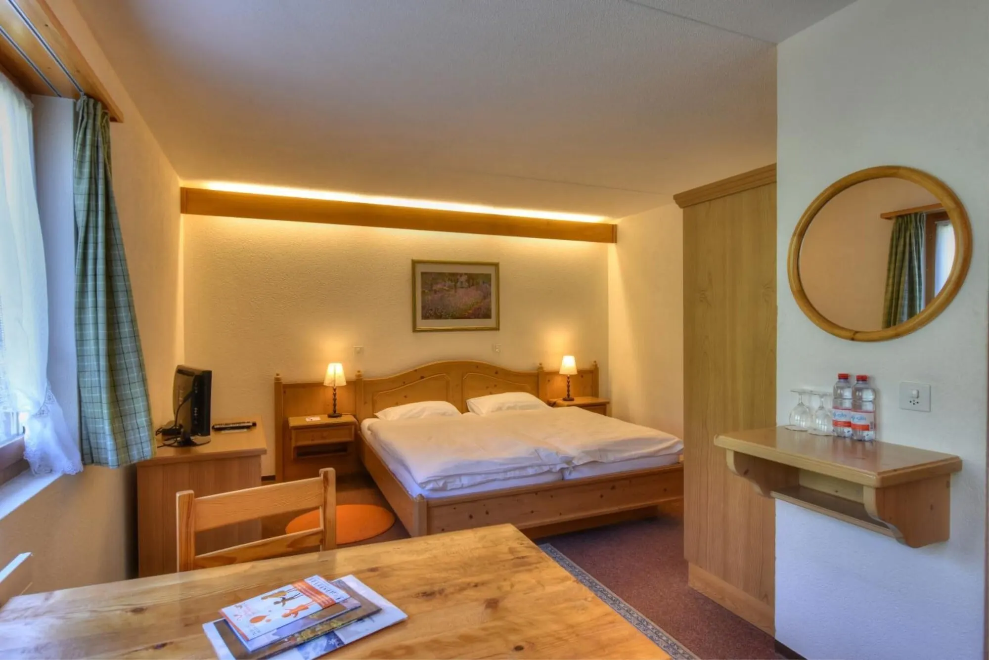 A double room with a round mirror