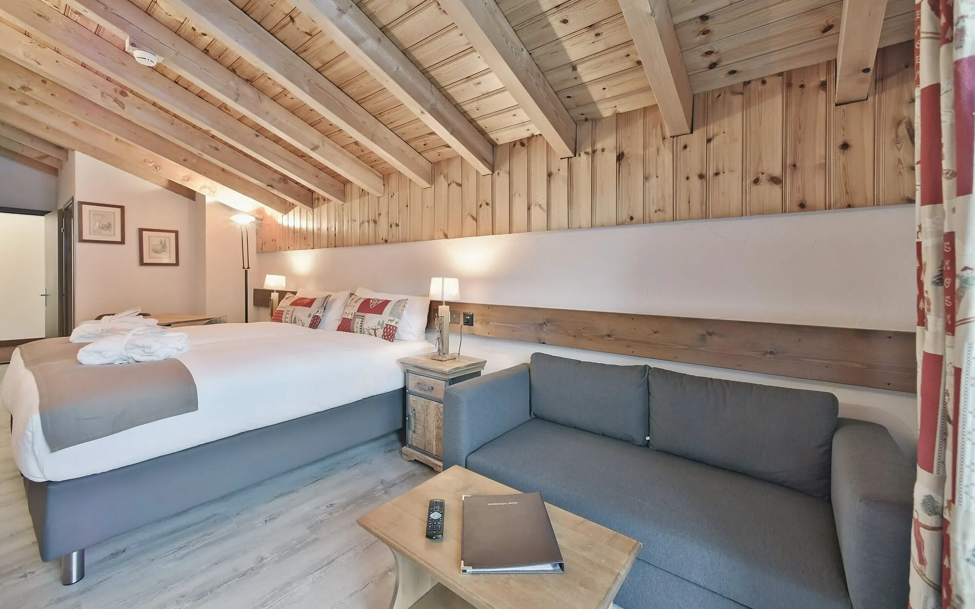 A room with a sofa under wooden beams