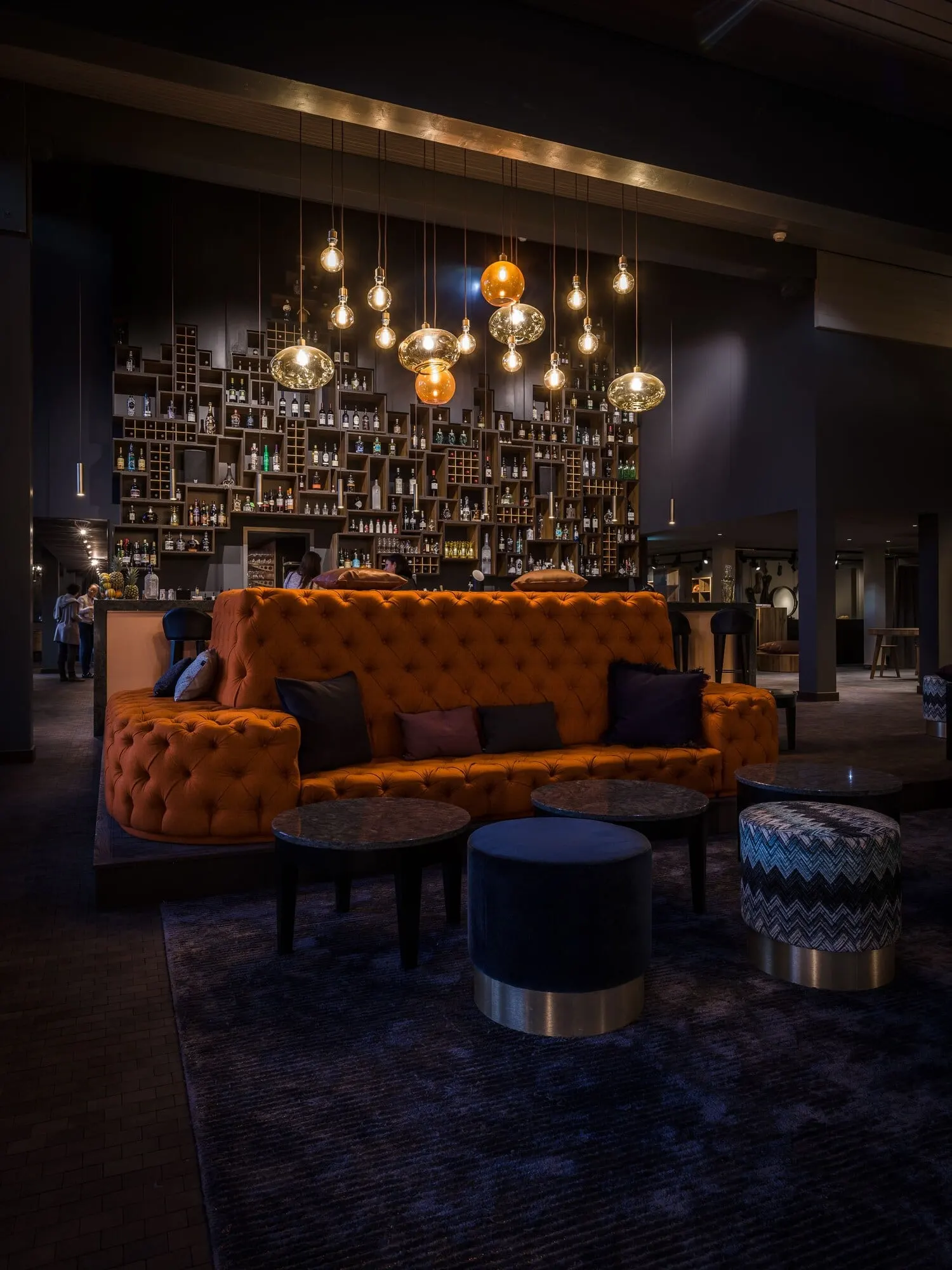 A lounge with a tufted orange sofa